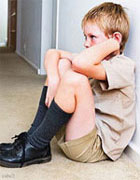 Boy sitting on floor in corridor